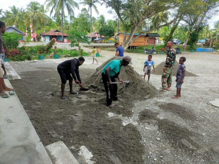 Gotong royong antara personel Satgas TMMD dan masyarakat Kampung Pigapu jelang penutupan TMMD. (Foto: NM)