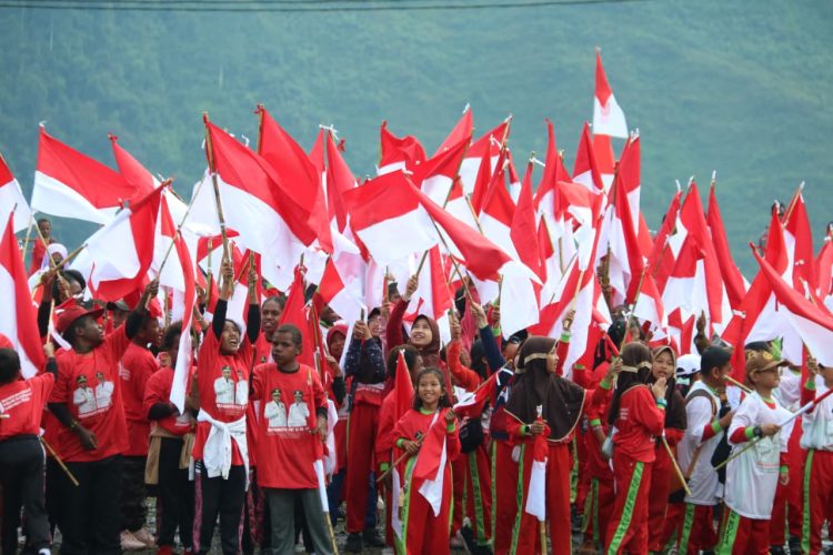 Satgas Yonif 112/Dharma Jaya (DJ) bersama pemerintah daerah dan ratusan warga menggelar Kirab Merah Putih yang memukau. (Foto: istimewa)