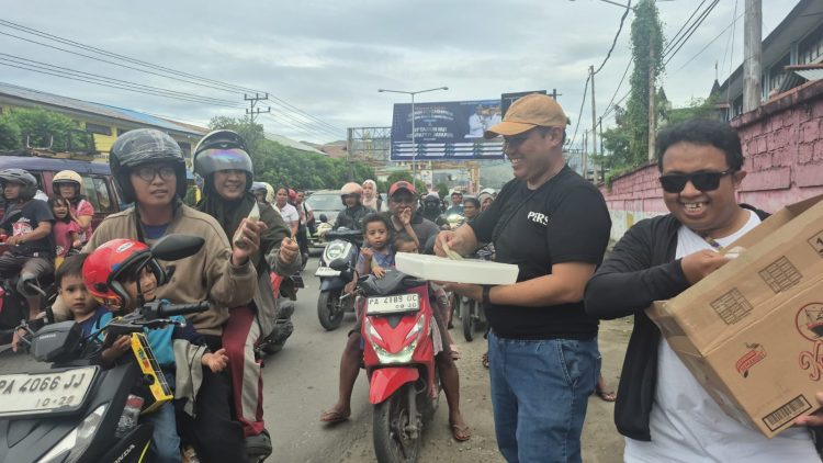 Berbagi takjil kepada masyarakat di pertigaan lampu merah Bandara Sentani. (Foto: Cornelia Mudumi)