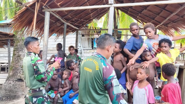 Personel Satgas TMMD Reguler ke-128 Kodim 1710/Mimika melalui kegiatan berbagi makanan ringan dan permen kepada anak-anak di Kampung Keakwa. (Foto: Istimewa)