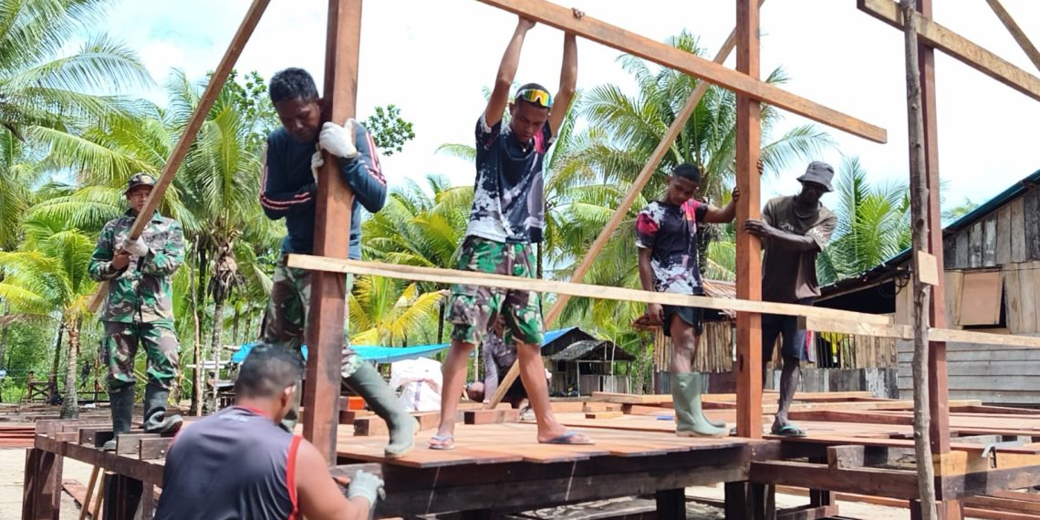 Personel Satgas TMMD bersama warga setempat tengah melaksanakan pemasangan rangka rumah. (Foto: Istimewa)