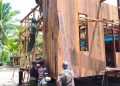 Satgas TMMD dan Warga Kebut Pemasangan Dinding Rumah Niko Makare