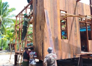Satgas TMMD dan Warga Kebut Pemasangan Dinding Rumah Niko Makare
