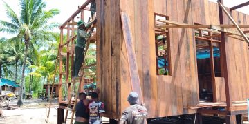 Satgas TMMD dan Warga Kebut Pemasangan Dinding Rumah Niko Makare