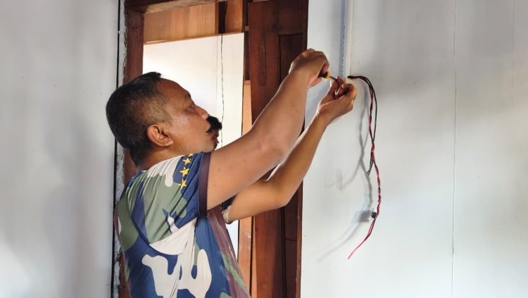 Proses pemasangan instalasi listrik pada sejumlah rumah warga program TMMD di Kampung Keakwa. (Foto: Istimewa)