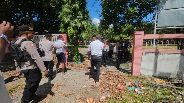 Personel Polres Jayapura membongkar palang yang dipasang di pintu gerbang sekolah oleh pihak yang mengklaim sebagai pemilik hak ulayat tanah. (Foto: Istimewa)