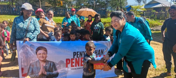 Bunda PAUD Kabupaten Puncak, Ny. Sujatinah Elvis Tabuni, saat menyerahkan bantuan seragam sekolah. (Foto: Istimewa)